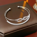 Detail eines silbernen zweischichtigen Armbands mit Zirkonia auf einer Schmuckschatulle - Silber