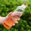 Minimalist transparent glass water bottle with orange time markers held in hand - 500ml / Gradient Orange