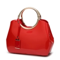 Chic red patent leather handbag for women featuring a round metallic handle on white backdrop - Red