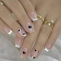 Detail of square nude pink press-on nails with silver glitter lines and heart patterns - CW778-Nude French Black Heart Dots