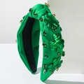 Dettaglio fascia verde annodata con trifogli di paillettes e pietre preziose di smeraldo - Verde