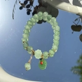 Green jade bead bracelet with flower charm and golden spacers on reflective mirror - S048-green Peace Buckle Donglin Jade Beaded Bracelet #sz350