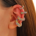 Detail of four colorful rhinestone ear cuffs in gold finish worn on the ear cartilage - Four-Piece Set / Multi-color