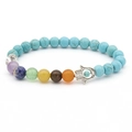 Türkis-Perlenarmband mit 7 Chakra-Steinen und silbernem Hand der Fatima Anhänger auf Weiß - Türkis Hamsa Armband