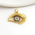 Macro detail of gold evil eye pendant featuring micro-paved blue and white cubic zirconia - Eye Shape