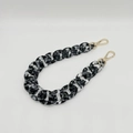 Macro shot of acrylic resin chain strap with black and white marble pattern and gold clasps - Leopard Black