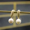 Round white freshwater pearl earrings with brushed gold finish on display stand - Long Oval Frosted Earrings