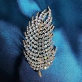 Elegant gold leaf brooch with sparkling crystals on premium blue satin background - Leaf Brooch