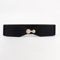 Detail of a wide black elastic belt featuring a polished gold circular metal buckle - Black