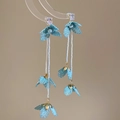 Nahaufnahme hellblauer Spitzenblumen-Ohrringe mit eleganten Perlenquasten-Anhängern - Silbernadel Blaue Blume