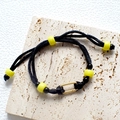 Handmade woven cord bracelet in black and yellow with gold engraved metal center - Black Woven Rope Yellow Beads Bracelet
