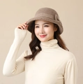Detail shot of a brown houndstooth bowler hat for women worn with a white sweater - Khaki