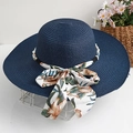 Détail d'un chapeau de paille marine avec perles blanches et un nœud en soie fleurie - Bleu marine