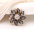 Detailed view of sunflower gemstone charm with grey rhinestones and gold alloy base - Gray