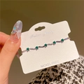 Elegant silver bracelet featuring emerald green stones and white zircon on jewelry card - 14K Gold Plated Copper / Silver Green