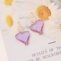 Dettaglio macro di orecchini a cuore viola con accenti floreali in zircone cubico - Viola