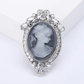 Broche camée vintage en relief avec cadre argenté et strass brillants sur fond blanc - Style de Relief de Dame / Argenté