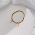 Detail of 18k gold beaded stretch bracelet with white pearl and daisy charm on silk - Gold Color - Daisy