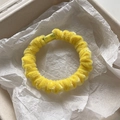 Detalle de un coletero de terciopelo amarillo brillante mostrando la suave textura de chenilla - Amarillo