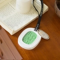 Green oval scented wax tablet with black ribbon on a rustic wooden table setting - Gardenia - Oval