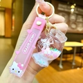 Close-up of pink Hello Kitty liquid glitter keychain with silicone strap and candy pendant - 【round Candy】milk White Kt