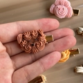 Macro shot of cute cream puppy cookie hair clip held in hand with gold metal base - Teddy Dog