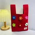 Red knit tote bag with 3D crochet flowers and white logo patch for daily commute - Colorful Flowers On A Red Background