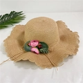 Detail view of woven straw sun hat with pink floral decorations and wavy edge - Adult M / Light Coffee