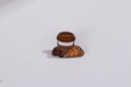 Spilla smaltata con tazzina di caffè, croissant e chicchi di caffè su fondo grigio - Caffè e Croissant