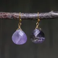 Detail view of purple teardrop stone earrings with gold wire wrap on a branch - Purple Heart/Teardrop Faceted Style (ER1060-6)