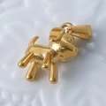 Macro shot of 24k gold-plated puppy shaped pendant in polished stainless steel - Dog / Gold