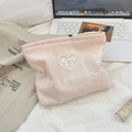 Trousse à maquillage rose côtelée avec écusson cœur en dentelle et broderie sur table - Rose