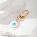 Golden alloy Evil Eye keychain charm with blue enamel detail on minimalist stone base - White