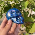 7cm Aura crystal skull hand-carved with rainbow sheen displayed in natural light - 7cm / Electroplated Blue
