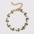 Dettaglio del bracciale boho dorato con ciliegia blu glitterata e foglia in smalto verde - Blu