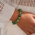 Macro shot of green marble-textured beaded bracelet worn on wrist with white knitwear - Bracelet / Green