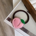 Détail d'un élastique à cheveux en acétate pêche rose avec strass et petite feuille - Pêche