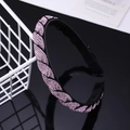 Detail view of pink rhinestone headband with non-slip teeth on black reflective surface - Pink Rhinestone