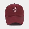Primer plano del bordado de cara sonriente blanca en una gorra de béisbol de algodón granate - Burdeos