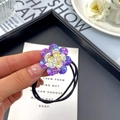 Elegant high-elastic hair tie featuring a sparkling K9 crystal flower in purple and yellow - Medium / Purple