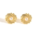 Dettaglio macro di orecchini vintage dorati a spirale con elegante perla centrale - Perla Rotonda a Spirale