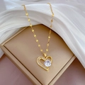Detail of a gold heart pendant with micro-pave crystals on a soft silk background - Gold