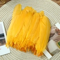 Macro shot of fluffy yellow goose feathers for DIY crafts on a round woven mat - Stiff Golden Yellow (50Pcs)