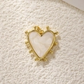 Detail of a heart-shaped pendant with gold metal frame and white pearlescent inlay - Gold White Pearlized Heart