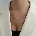 Silver layered tassel necklace in titanium steel on model with white blazer - Short Style / Steel