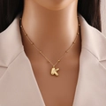 Golden 3D balloon letter K pendant necklace with bead chain on female model - Letter K