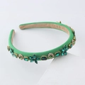 Detail of luxury emerald velvet headband with green crystals and gold accents - Dark Green