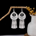 Vintage silver tassel earrings with flower hollow design on a rustic branch display - Silver Hollow Carved Long Tassel Style (E5824)