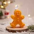 Orange gingerbread man scented candle on wood base with festive holiday decor - Orange Gingerbread Man