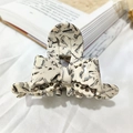 Elegant bow hair claw with black and white marble acetate finish for stylish updos - Cream Marble